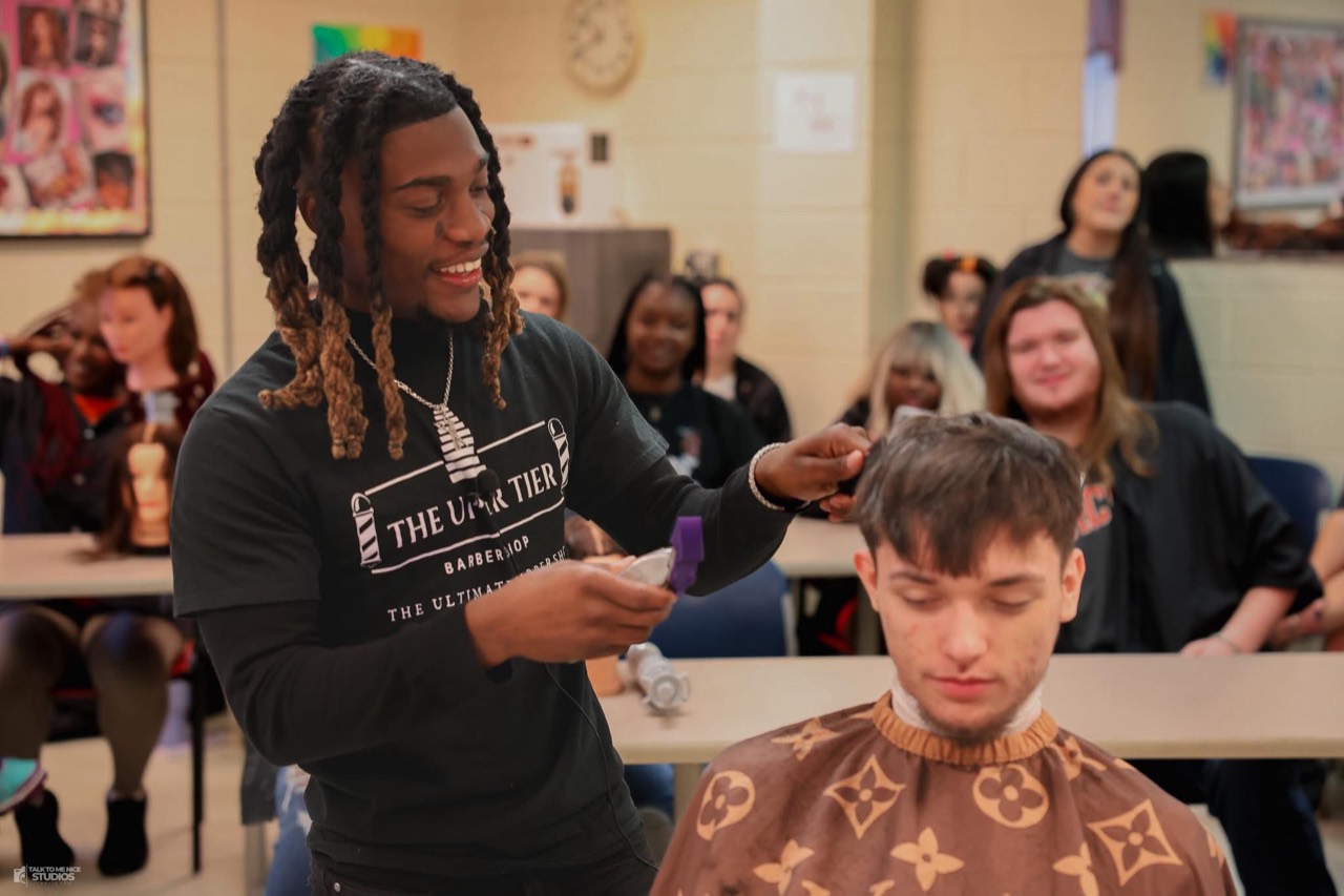 Keshawn Brown demonstrating barbering techniques for a classroom audience
