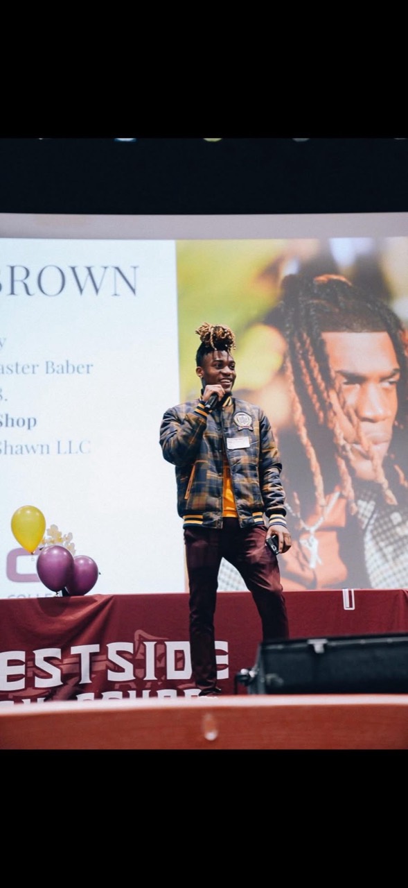Keshawn Brown speaking onstage with a microphone
