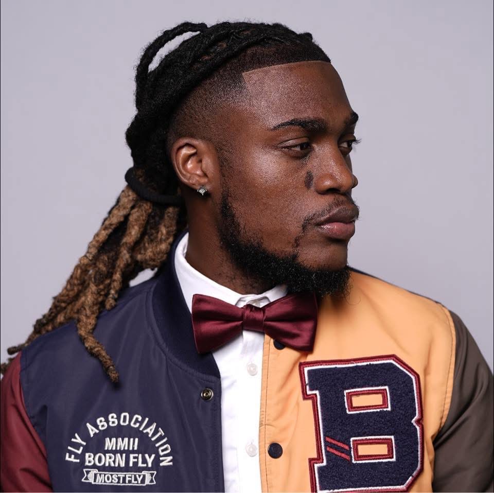 Studio portrait of Keshawn Brown in a varsity jacket and bow tie
